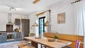 A modern kitchen with a wooden table, bench, and purple chair. - Chalet in Leogang near Ski Lifts (Leogang)