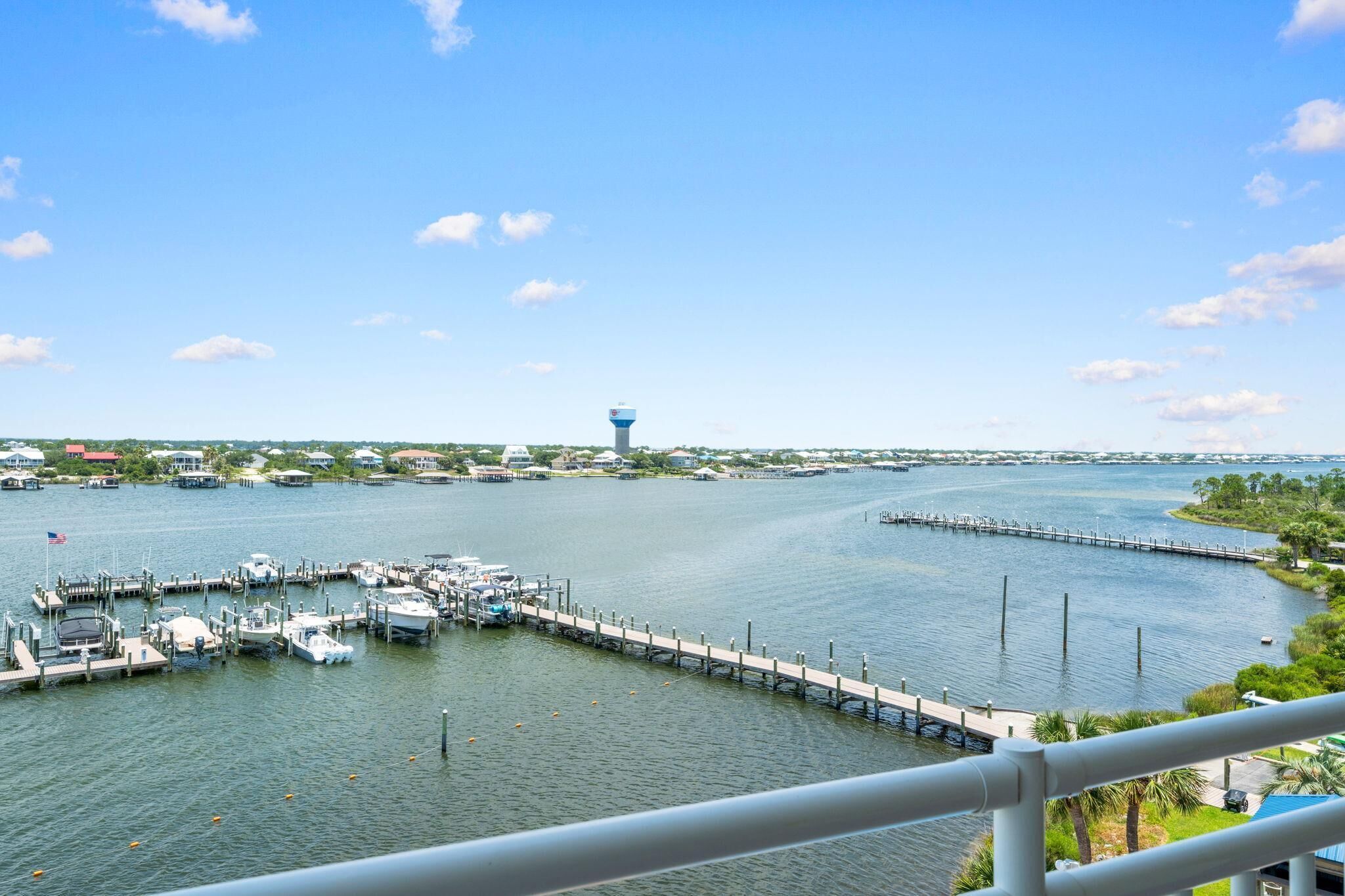 A marina with boats docked, a water tower, and a clear sky.