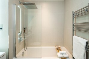 A modern bathroom with a glass-enclosed shower, a bathtub, and a towel rack. - 16 Minutes Walk To London Eye/shard View & Balcony (London)