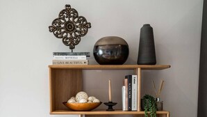 A dining area with a wooden table set for a meal, surrounded by shelves with decorative items and books. - 16 Minutes Walk To London Eye/shard View & Balcony (London)