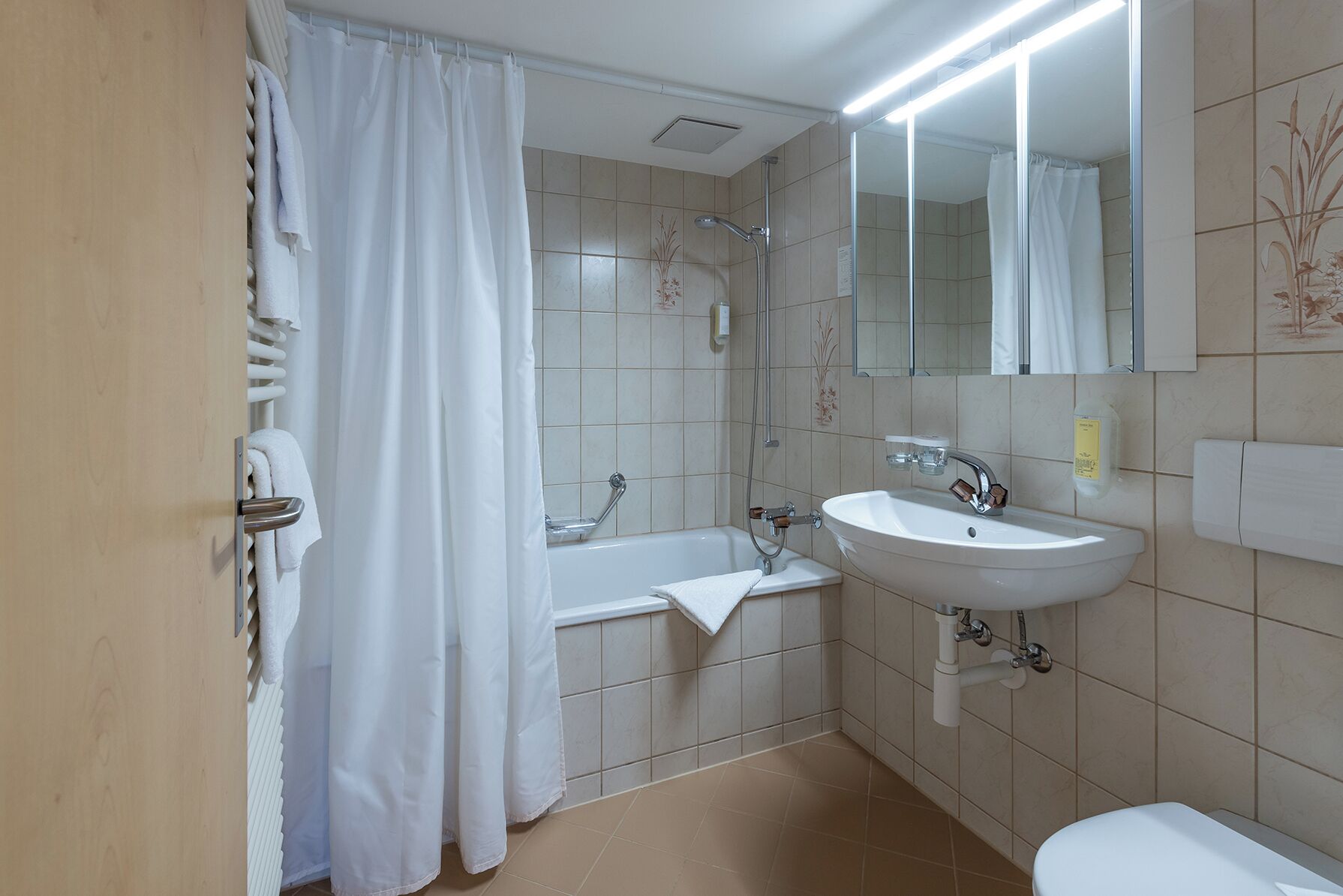 Un baño con bañera, lavamanos e inodoro.