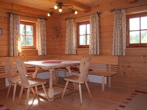 A wooden cabin interior with a dining table, four chairs, and two benches. - Farmhouse in Hopfgarten near SkiWelt (Hopfgarten im Brixental)