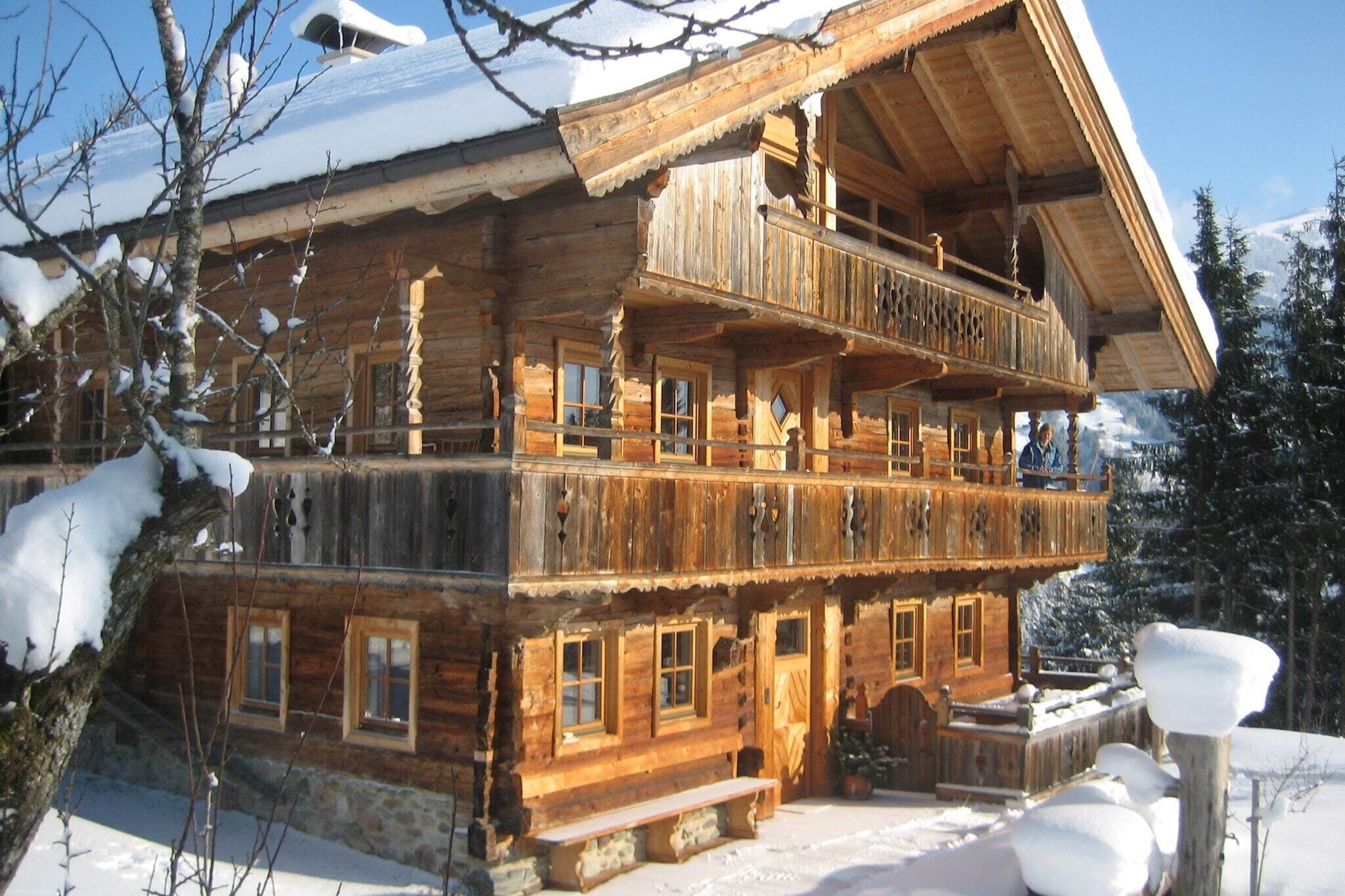 Una cabaña de madera de varios pisos con balcones, en un paisaje nevado.
