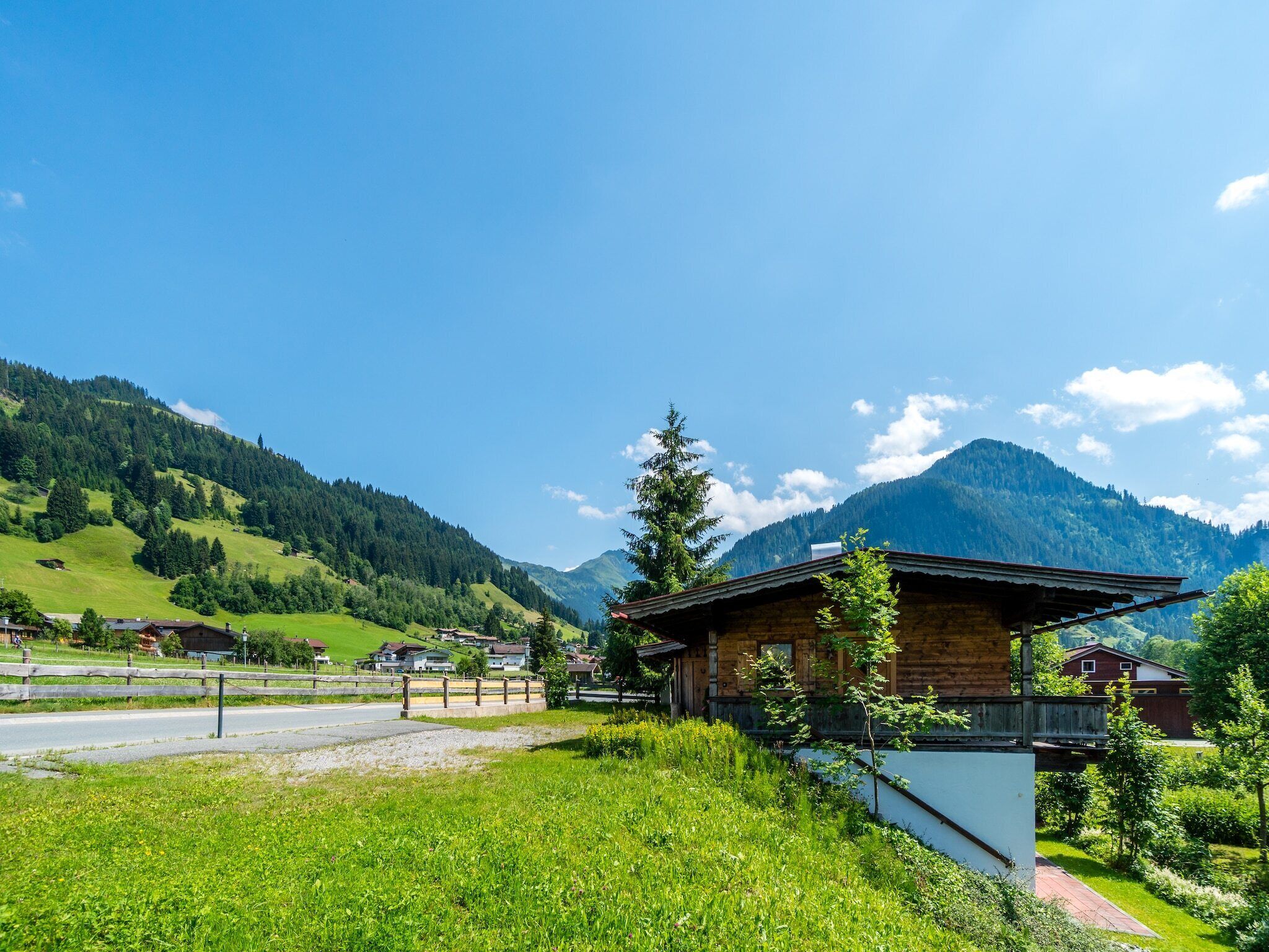 Un paysage de montagne rural avec une cabane en bois et des maisons.