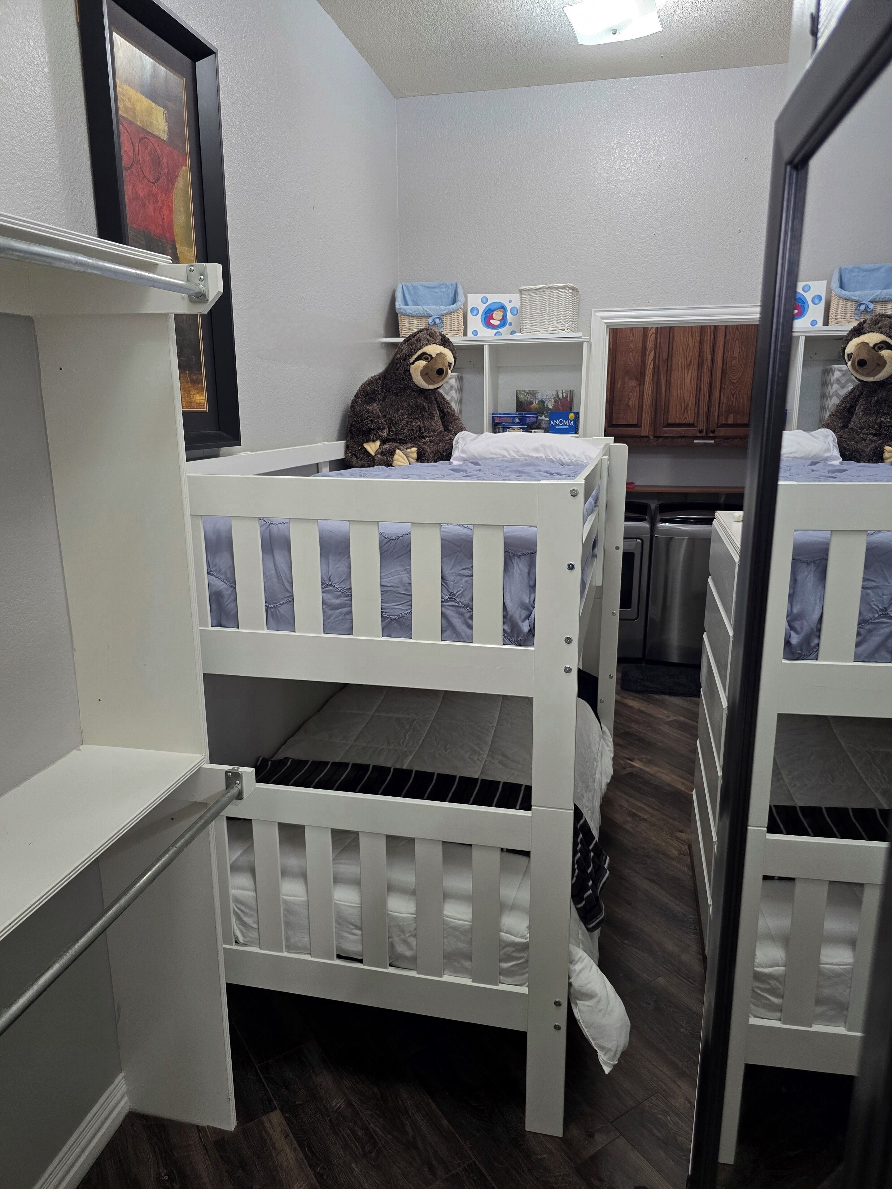 Una habitación con literas, una kitchenette pequeña y un espejo.