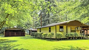 Une maison de plain-pied à l’extérieur jaune, avec un garage et une pelouse bien entretenue.