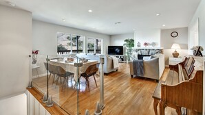A spacious living area with a dining table, sofa, and TV.