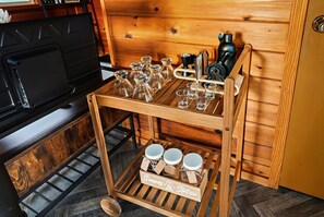 A wooden cart with glassware and mugs, a coffee machine, and a sign that reads 'S'mores Station'.