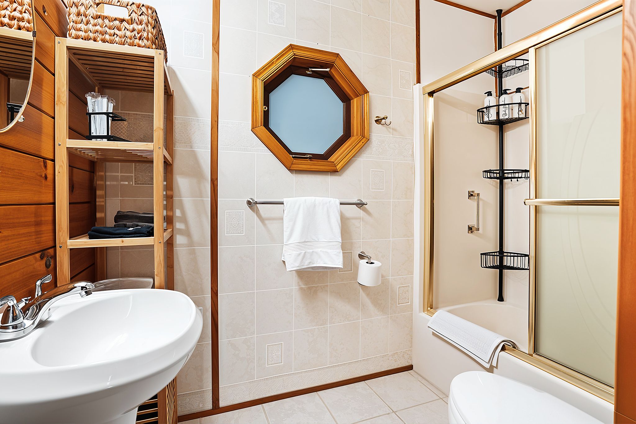 Un baño con tocador de madera, un espejo grande, una bañera y una zona de ducha.