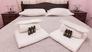 A neatly made bed with white linens, two bedside tables with lamps, and toiletries on the bed. - Classic Koukaki Living 2 Bd with Balcony (Athens)