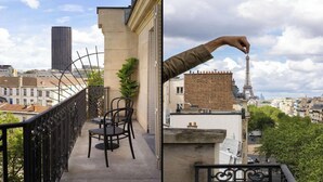 Un balcón con vistas a la Torre Eiffel, un edificio alto y una estructura de ladrillo.