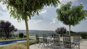 An outdoor seating area with a pool, surrounded by trees and a view of the countryside. - Scenic Theux Retreat with Pool & Garden. (Theux)