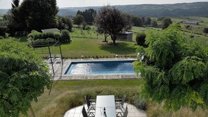 A swimming pool with a patio area, surrounded by greenery and a view of the countryside. - Scenic Theux Retreat with Pool & Garden. (Theux)