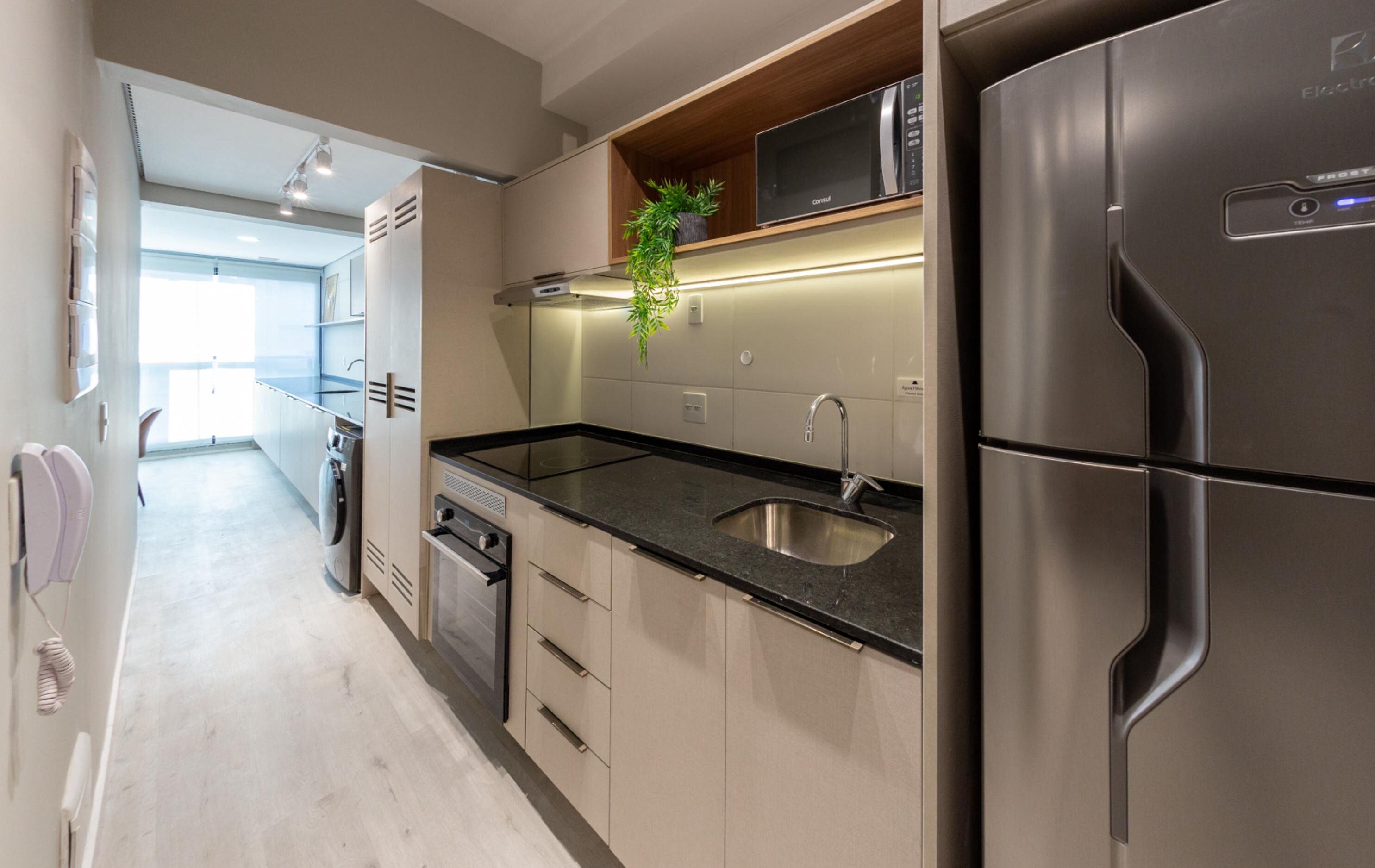 Una cocina moderna con electrodomésticos de acero inoxidable, horno empotrado y pileta.