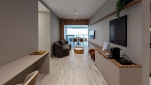 Un salon moderne comprenant un canapé, une table basse et un coin repas avec des chaises et une table.