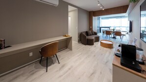 Un salon moderne comprenant un canapé, une table basse et un coin repas avec des chaises.