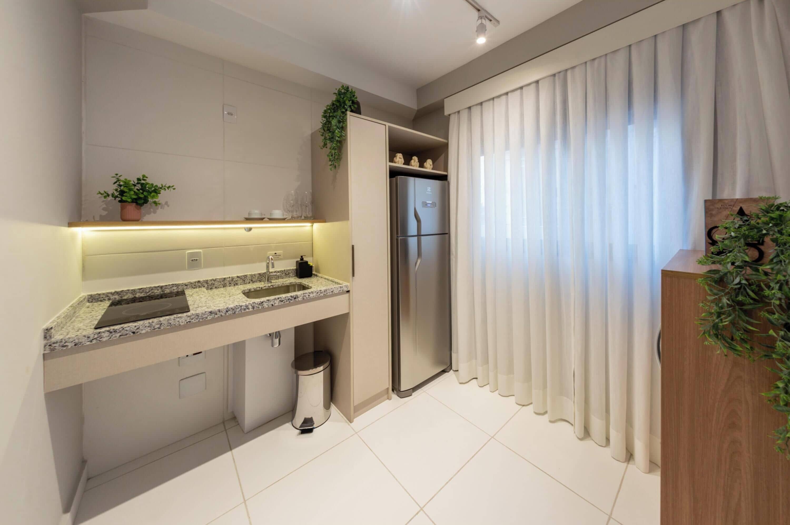 Una cocina moderna con horno empotrado, refrigerador de acero inoxidable y una encimera con pileta.