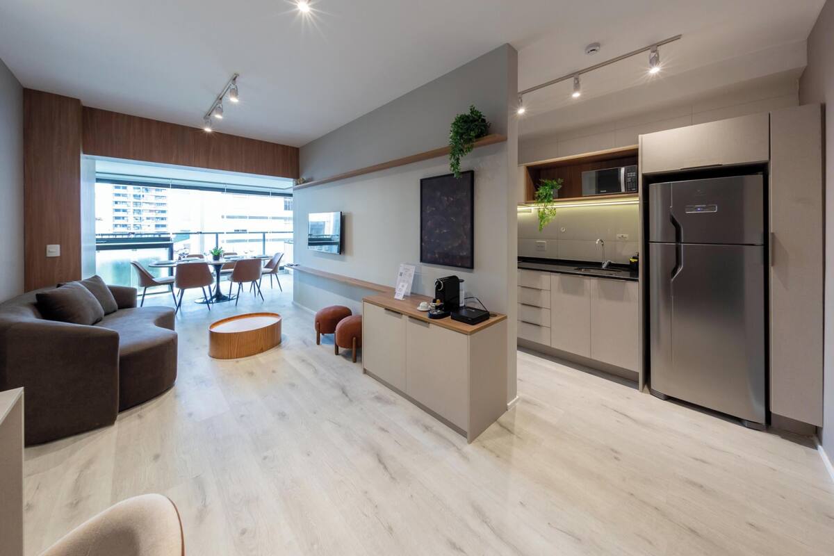 A modern kitchen with a built-in refrigerator, wooden cabinets, and a coffee machine.