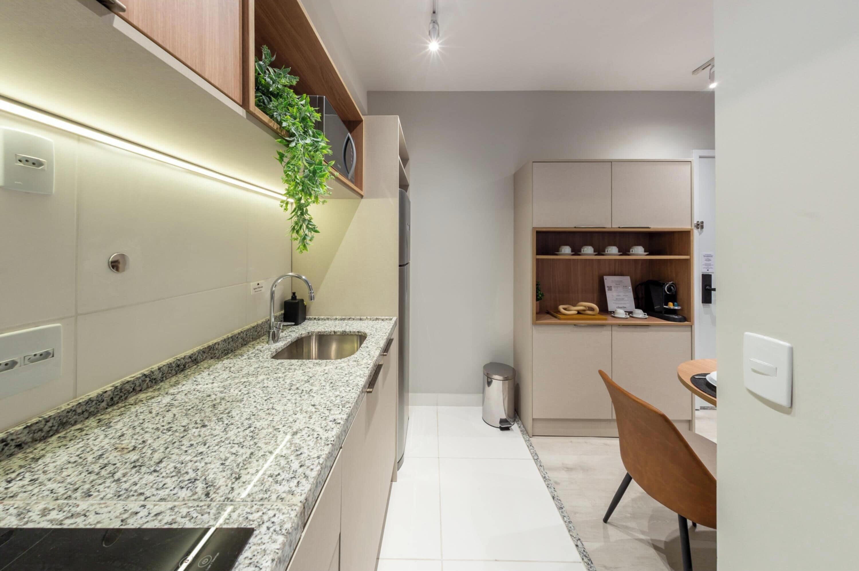 A modern kitchen with granite countertops, a stainless steel sink, and wooden cabinets.