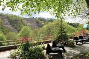A terrace with a view of a valley, outdoor seating, and a railing. - La Roche Riverside Mansion (La Roche en Ardenne)