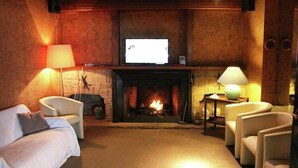 A cozy room with a fireplace, a television, and seating arrangements.