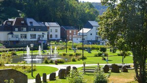 A residential area with houses, a fountain, and a park with stone sculptures.