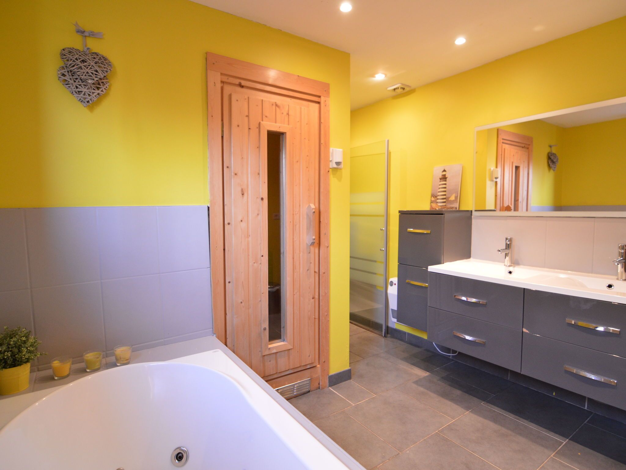 Une salle de bain moderne avec une porte en bois, une baignoire et un meuble-lavabo avec un miroir.