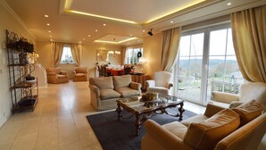A spacious living room with a large window, a dining area, and a balcony with a view. - Forestside Retreat, Malmedy (Malmedy)