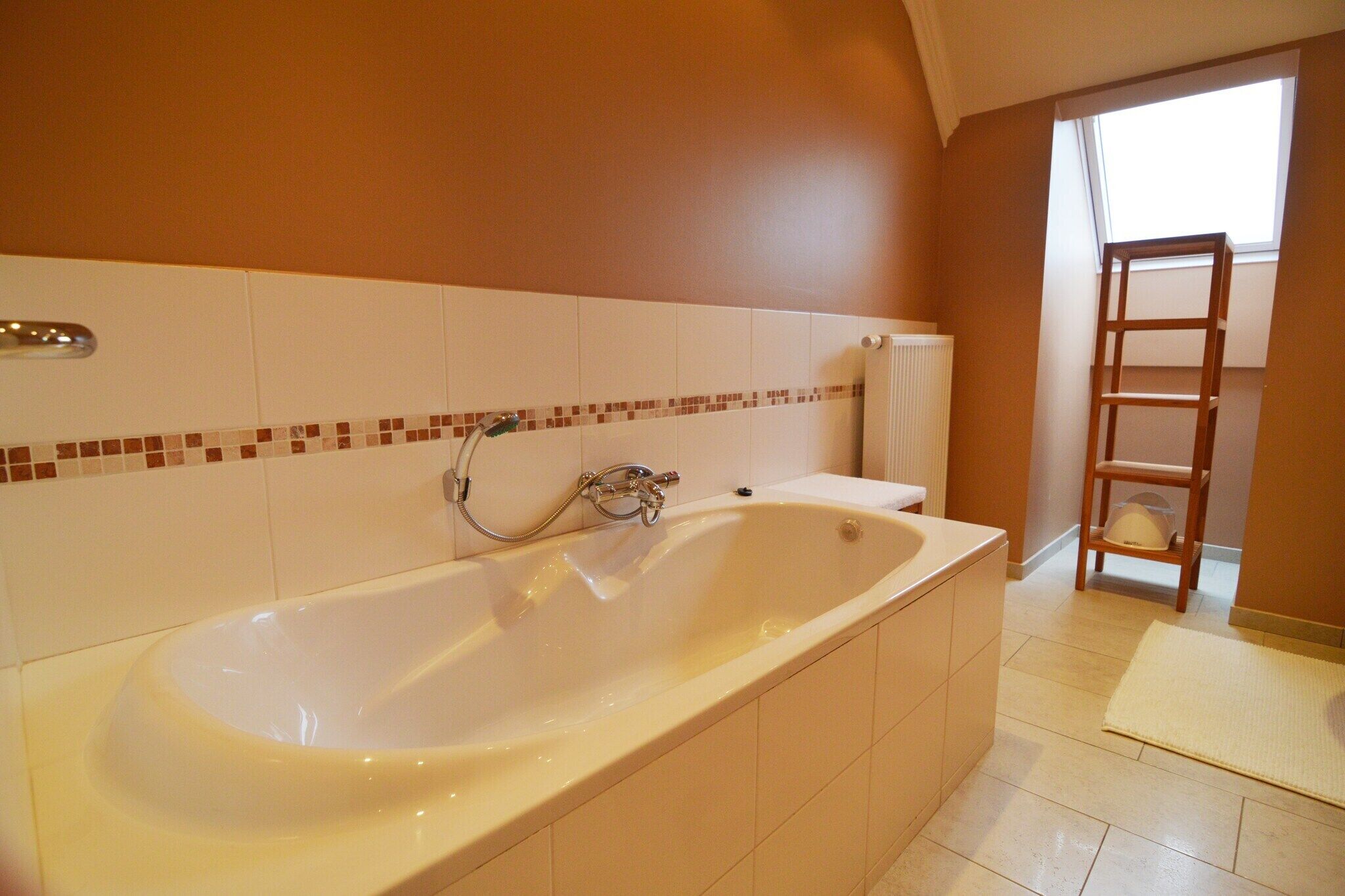A bathroom with a large bathtub, a shower, and a wooden ladder leaning against the wall.
