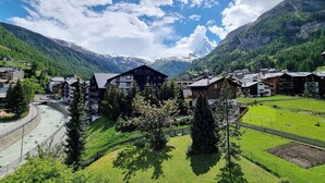 A mountain village with traditional wooden houses, a river, and a clear sky. - Haus Matten - Studio Findeln (Zermatt)
