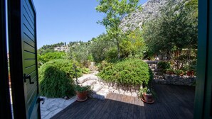 En træterrasse med plantekasser og en stenvæg.