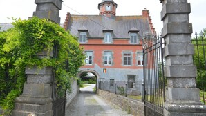 Ein historisches Gebäude mit einem zentralen Bogen, Steinsäulen und einem Turm.