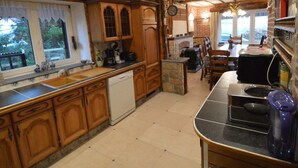 A rustic kitchen with wooden cabinets, a dishwasher, and a stone island. - Modern Spacious Holiday Home (Mettet (maison st Gérard))
