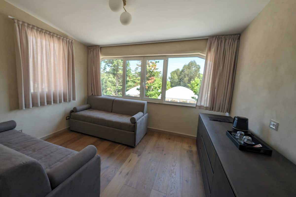 A room with a sofa, a small table with a tray, and a window with curtains.