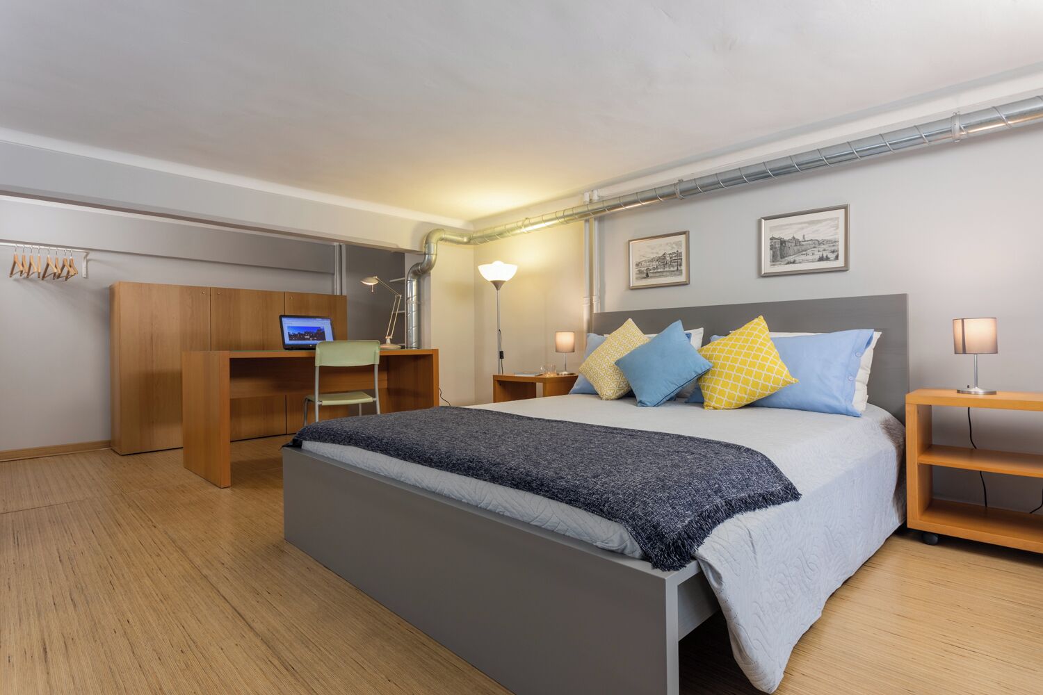 A modern bedroom with a large bed, a desk, and a chair.