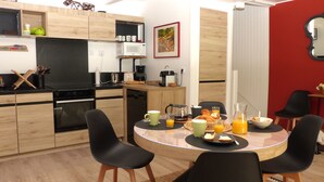 Eine moderne Küche mit Holdekor, einem Esstisch mit Stühlen und Frühstücksgebäck.