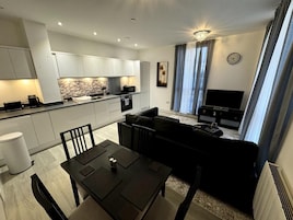 A modern apartment with a kitchen, dining area, and living room.