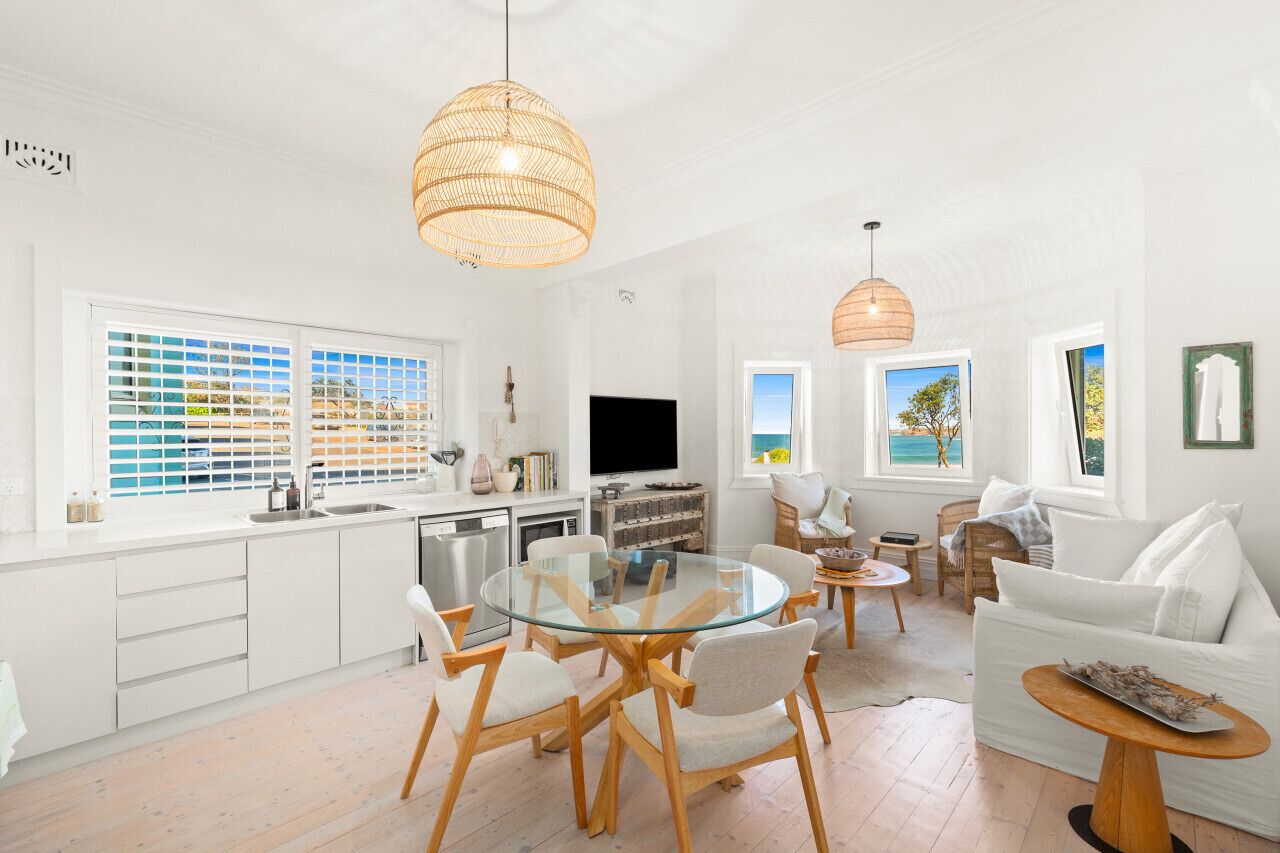 A bright, open-plan living space with a kitchen, dining area, and seating area.