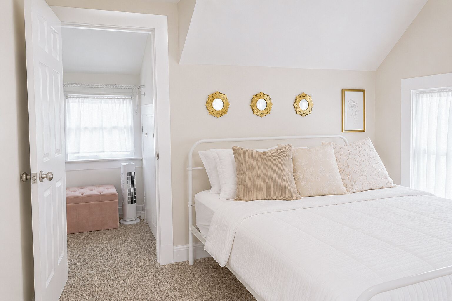 A bedroom with a white bed, a bench, and a radiator. There are three wall decorations and a framed picture.