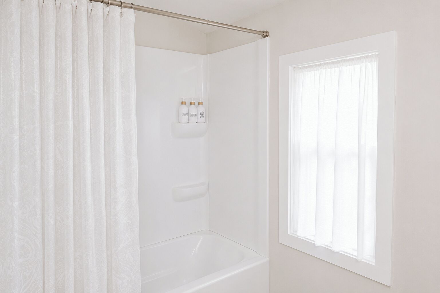Een badkamer met een douche, een raam en toiletartikelen aan de muur.