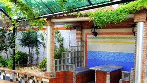 A covered outdoor seating area with mosaic tile walls, a bench, and a small table. - Exclusivo Loft en Zaragoza-2 (Movera)