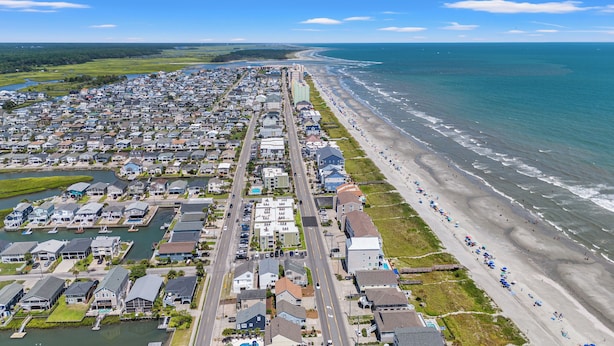 A coastal residential area with houses, a beach, and a marina.