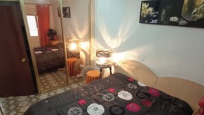 Una camera da letto con un letto, uno specchio, una lampada e un quadro appeso al muro.