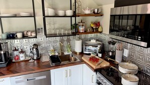 A modern kitchen with a built-in oven, coffee maker, and various utensils.