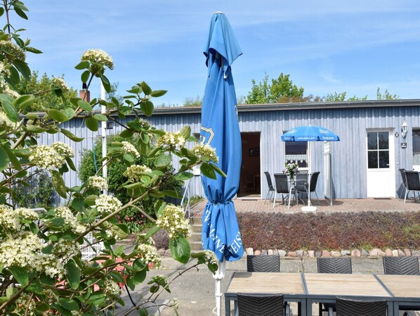 A building with a blue awning and outdoor seating area.