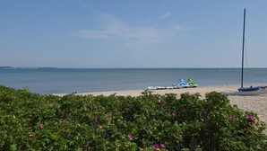 A beach with a clear sky, calm sea, and boats. - Ferienhaus in Damshagen mit Sauna (Klütz)