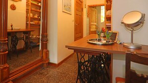 A room with a wooden dining table, chairs, a mirror, and a shelf with decorative items. - Romantische Ferienwohnung in Boldenshagen (Kröpelin OT Boldenshagen)