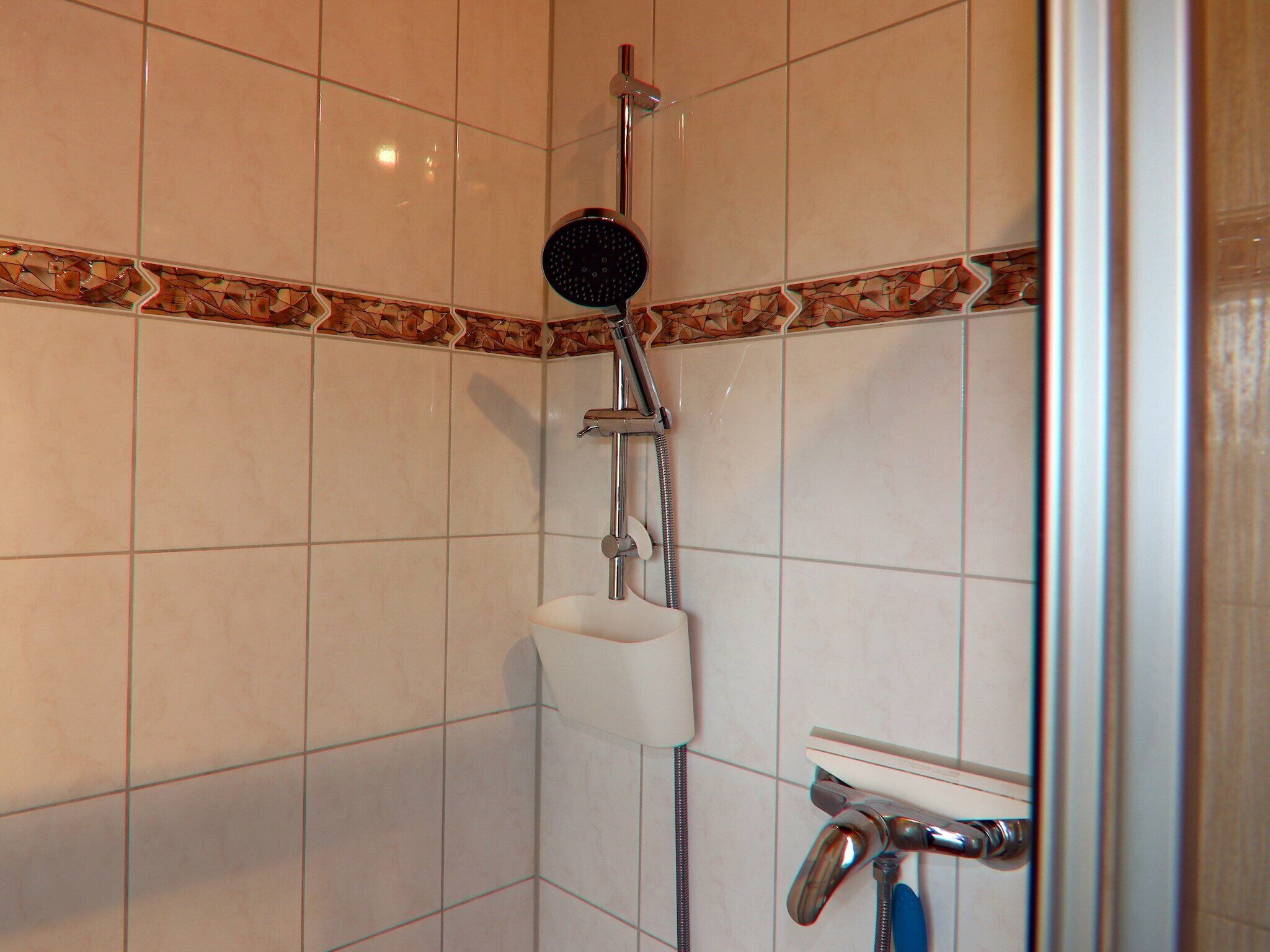 A shower with a handheld showerhead and a handheld faucet.