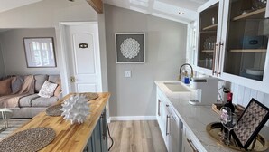 Eine moderne Küche mit einer Holz Arbeitsplatte, weißen Schränken und einem eingebauten Backofen.