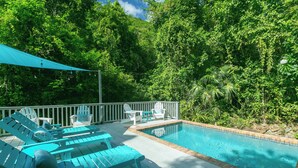 A pool with blue lounge chairs and a white deck. - Villa de Paz, STJ 4 BR/2.5B, 2-8 guests Pool Private Renovated AC backup power (St John)